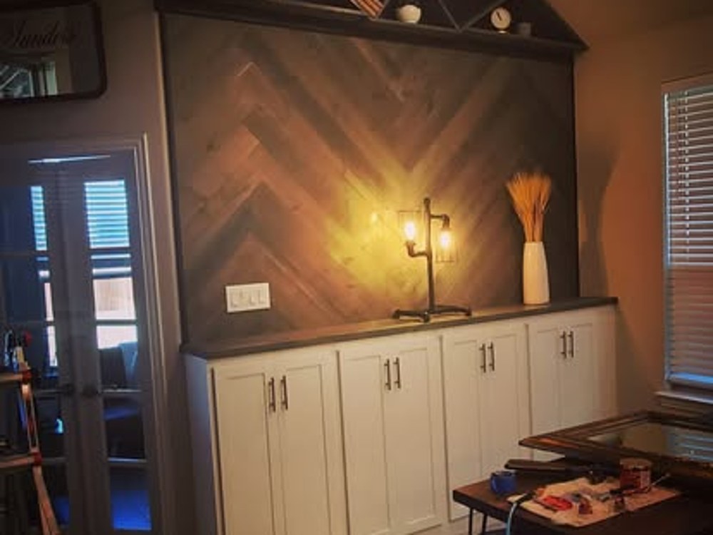 Built-in cabinetry with herringbone accent wall and shelf