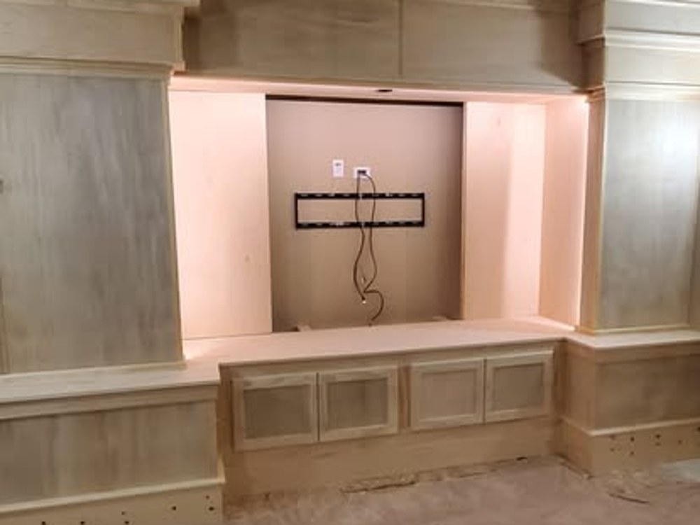 Custom media wall cabinetry with raised panel doors, in progress