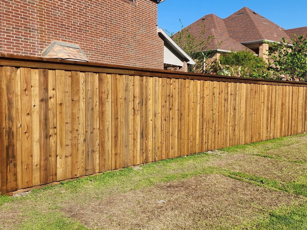 Board-on-board cedar privacy fence with dark stain, corner view