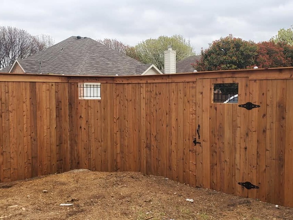Cedar privacy fence corner with two iron-window gates