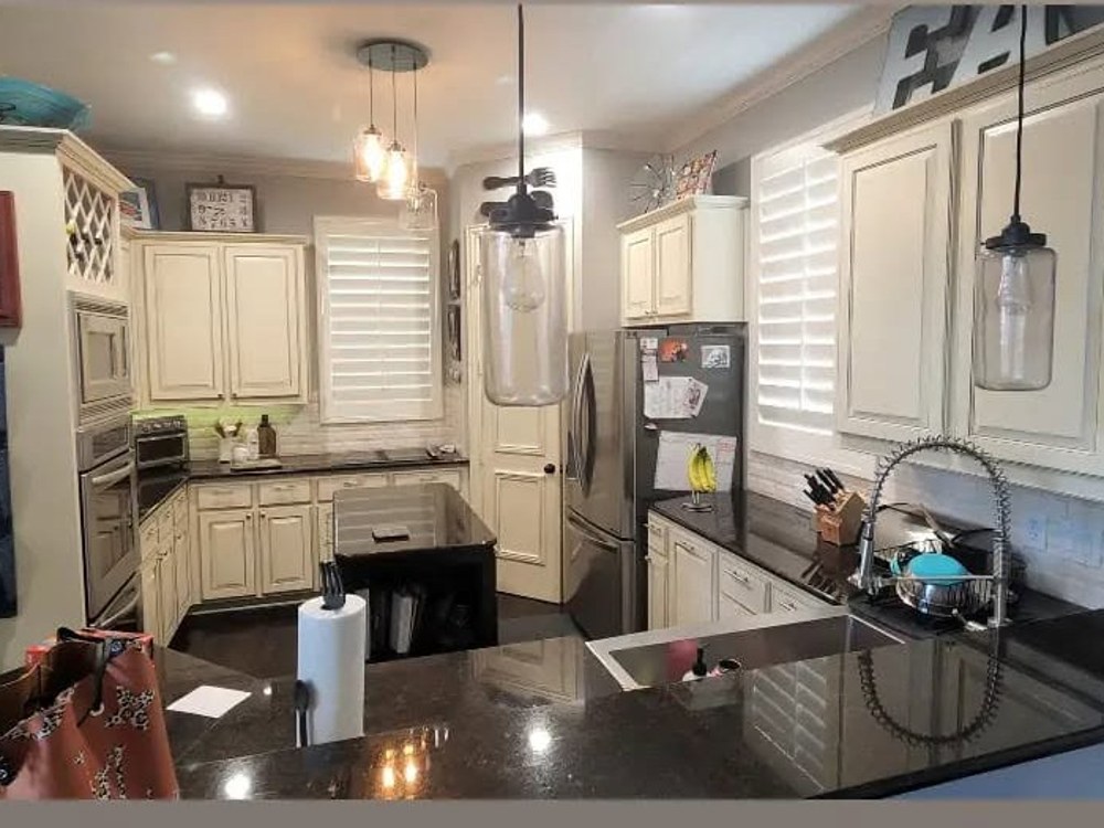 Kitchen before remodel, dated cabinetry and black granite